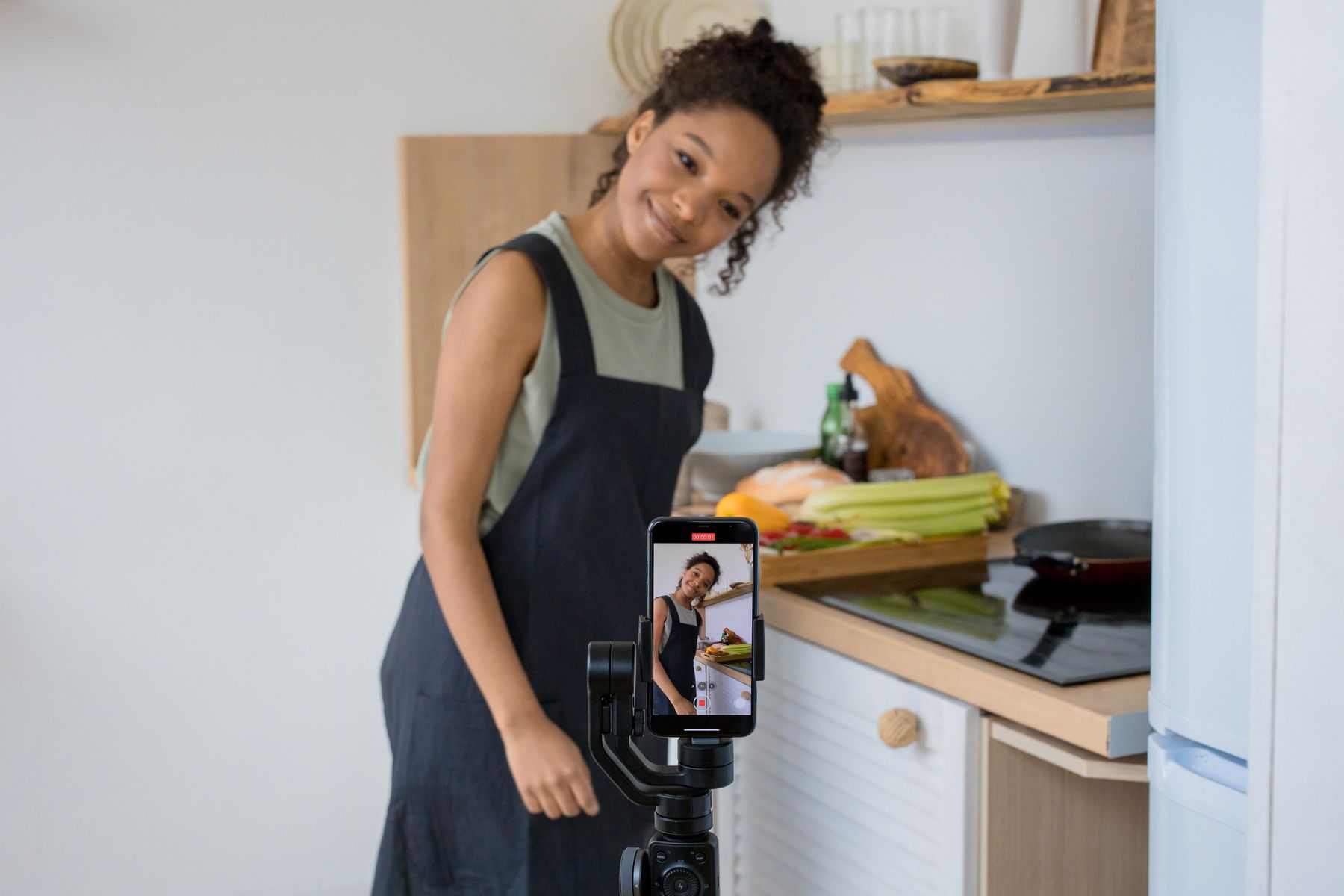 Mujer sonriente grabando un vídeo en casa con el móvil